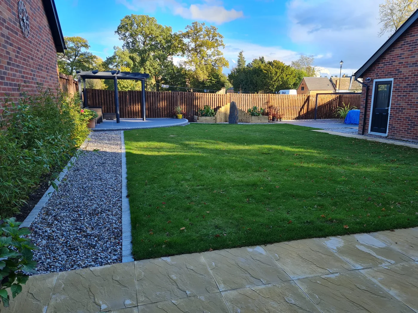 Finished landscaped lawn with paving, gravel border and planting