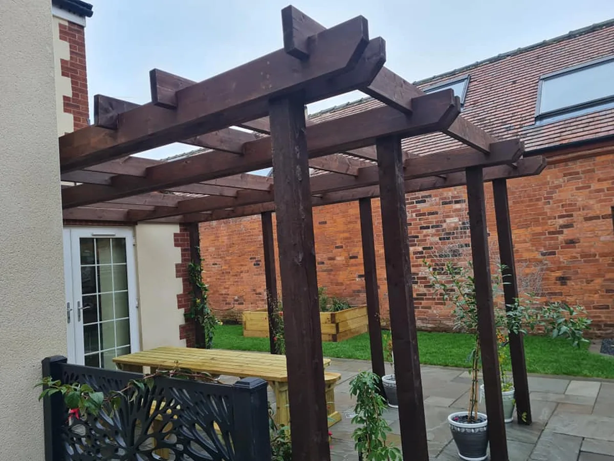 Timber pergola structure over a paved garden seating area